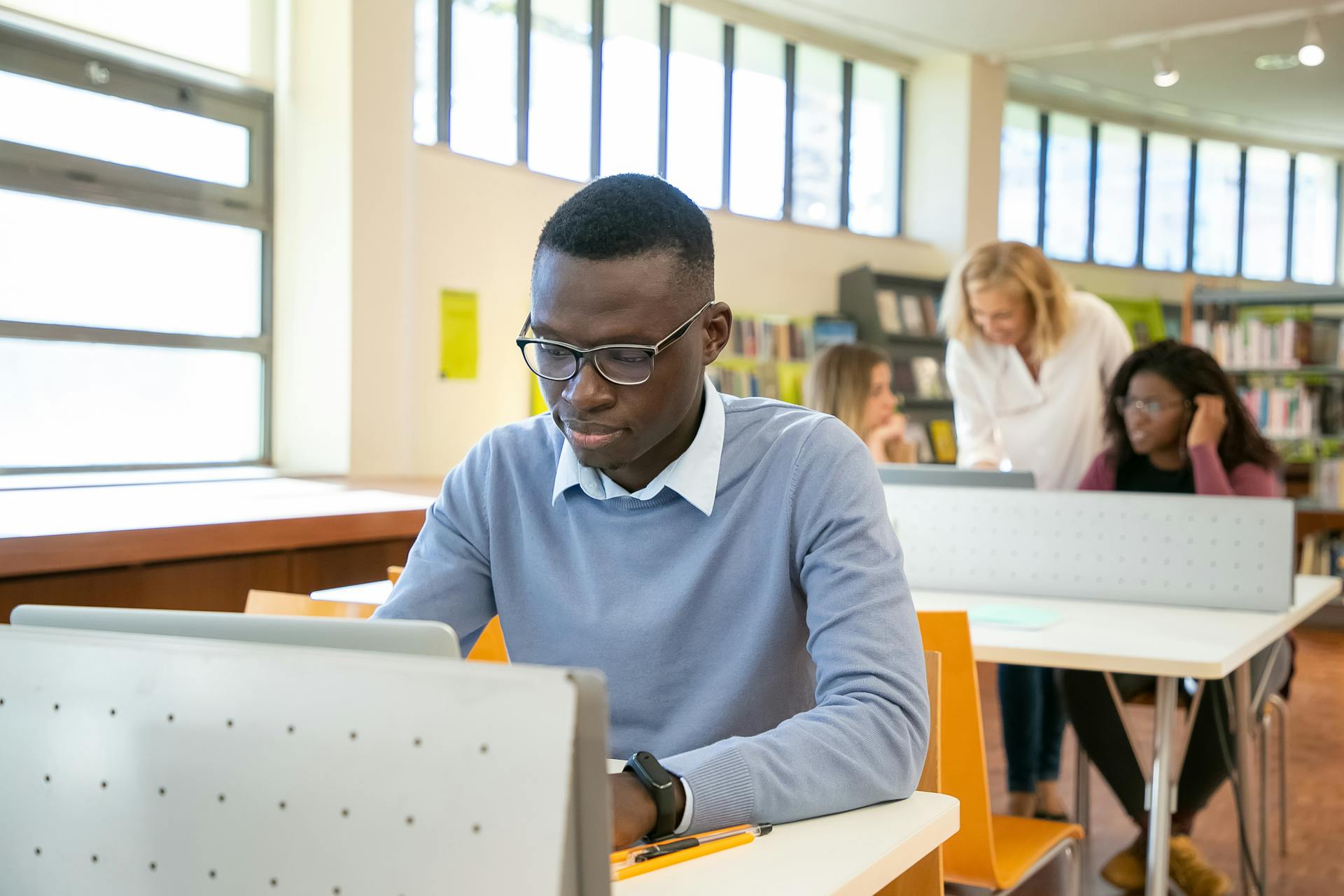 Étudiant en cours de formation linguistique chez AMBIZ Abidjan, travaillant sur ordinateur portable en salle de classe
